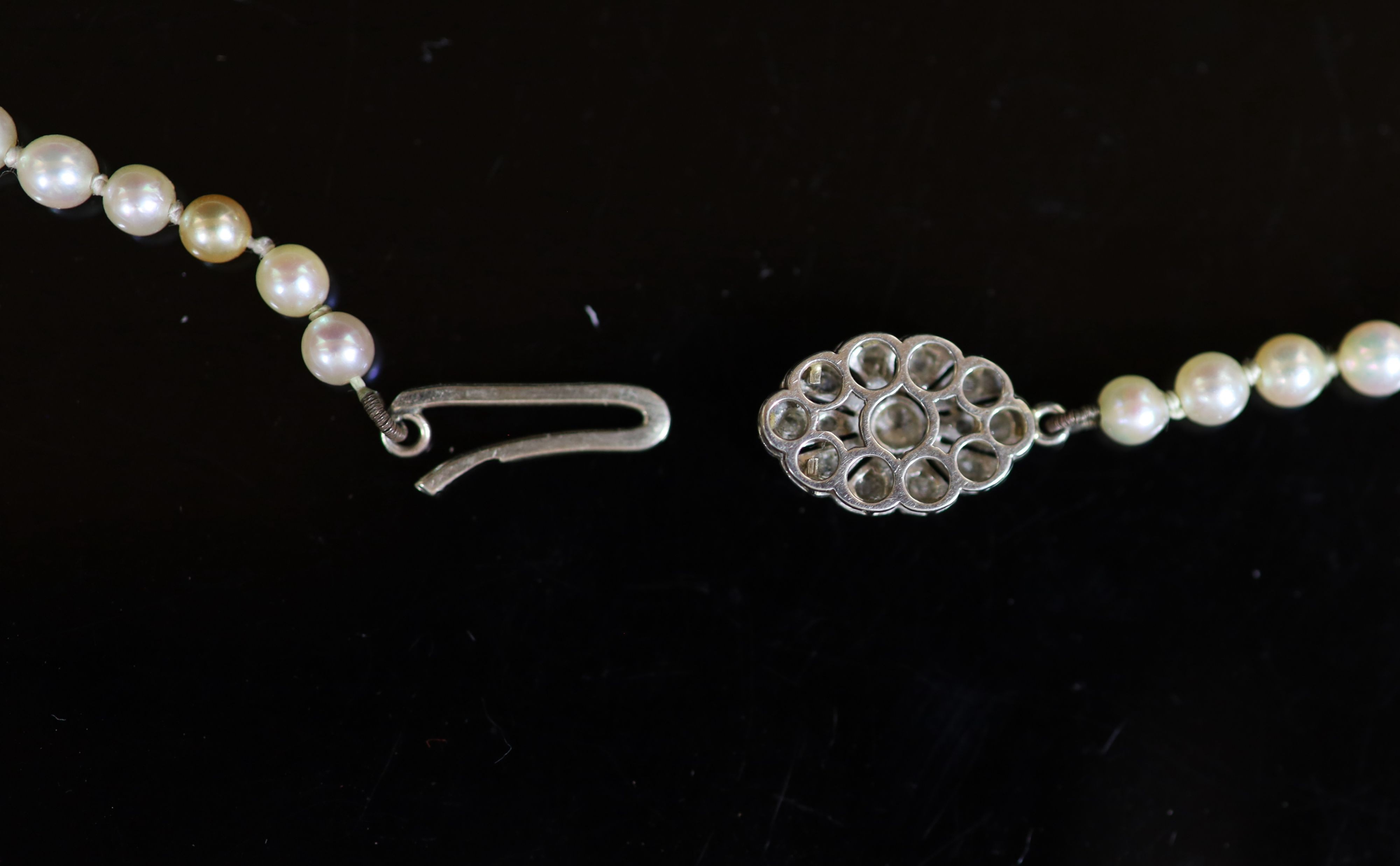 An early 20th century graduated pearl necklace, with platinum and millegrain set diamond clasp